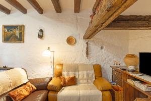 a living room with a couch and a television at Ca l'Emilli in Gélida
