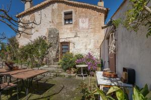 an outdoor patio with a table and a building at Ca l'Emilli in Gélida