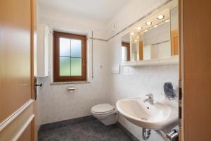 a white bathroom with a toilet and a sink at Hienerhof in Moso +23 photos