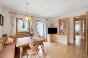 a living room with a wooden table and a television at Hienerhof in Moso