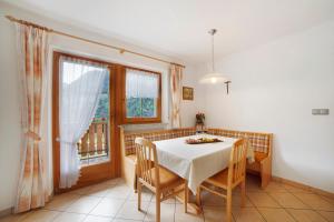 a dining room with a table and chairs and a window at Hienerhof in Moso