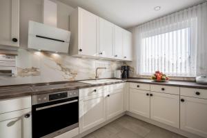 a kitchen with white cabinets and a sink at Ferienhaus Lübeck Buntekuh in Lübeck