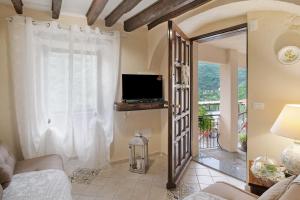 a living room with a television and a couch at Agriturismo U' Spigu Nonna Annetta in Nasino