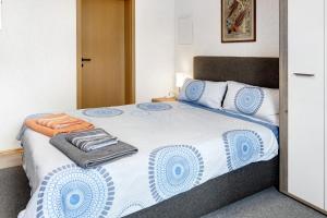 a bedroom with a large bed with blue and white sheets at Ferienwohnung Im Bohrer in Donaueschingen