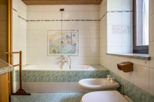 a bathroom with a toilet and a tub and a sink at Casa Delmarco in Castello di Fiemme +28 photos