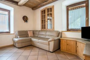 a living room with a couch and a tv at Casa Delmarco in Castello di Fiemme