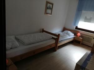 two twin beds in a room with a window at Luitje Gasthuus in Krummhörn