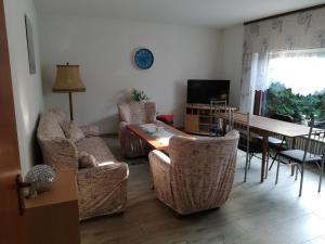 a living room with a table and chairs and a dining room at Luitje Gasthuus in Krummhörn