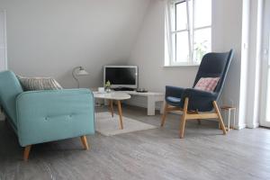 a living room with two chairs and a table and a tv at Ferienwohnung Traumblick in Reesdorf