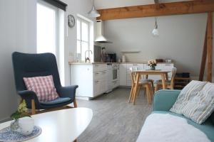 a living room with a table and chairs and a kitchen at Ferienwohnung Traumblick in Reesdorf