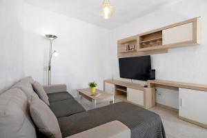 a living room with a couch and a flat screen tv at Casa Lía in La Santa