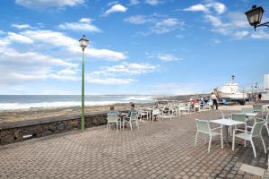 a group of tables and chairs on the beach at Casa Lía in La Santa