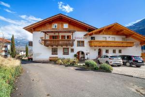 a building with a balcony and cars parked in a parking lot at Fröhlichhof Wohnung Panorama in Lagundo