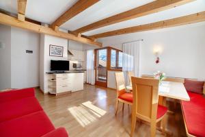 a living room with a red couch and a table at Fröhlichhof Wohnung Panorama in Lagundo