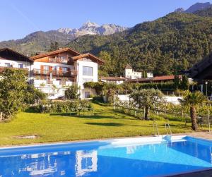 a resort with a swimming pool and mountains in the background at Fröhlichhof Wohnung Panorama in Lagundo +22 photos