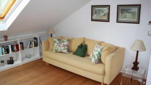 a living room with a couch with pillows on it at Haus Elbrächter Ferienwohnung 2 in Gstadt am Chiemsee
