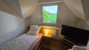 a small bedroom with a bed and a window at Kiepe im Münsterland in Nordwalde