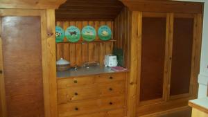 a wooden cabinet with plates on top of it at Haus Elbrächter Ferienwohnung 2 in Gstadt am Chiemsee +10 photos