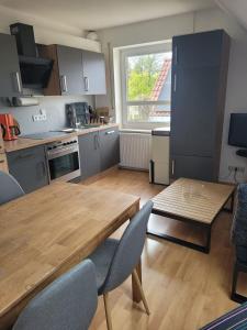 a kitchen with a wooden table with chairs and a wooden table at Kiepe im Münsterland in Nordwalde +2 photos