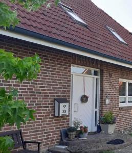 a brick house with a white door with areath on it at Kiepe im Münsterland in Nordwalde