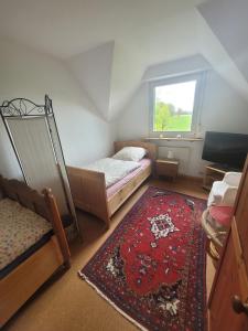 a small room with two beds and a red rug at Kiepe im Münsterland in Nordwalde