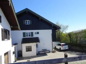a white house with a small dog house at Haus Elbrächter - Erdgeschoss in Gstadt am Chiemsee