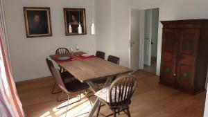 a dining room with a wooden table and chairs at Haus Elbrächter - Erdgeschoss in Gstadt am Chiemsee +16 photos
