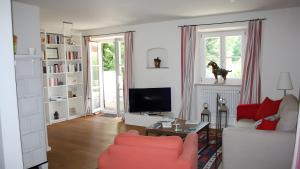 a living room with a couch and a tv at Haus Elbrächter - Erdgeschoss in Gstadt am Chiemsee