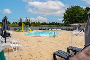 a swimming pool with white chairs and a playground at Euro Mobil B16 in Boofzheim