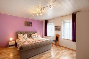 a bedroom with a bed and purple walls at Ferienwohnung Failte in Niederselters