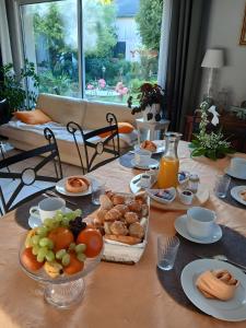 a table topped with plates of food and fruit at Chambres D'hôtes Au Gré Du Temps in Saint-Aignan