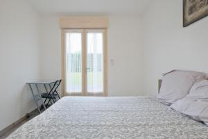 a bedroom with a bed and a chair and a window at Chalet avec piscine privée in Savignac-les-Églises +19 photos