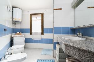 a blue and white bathroom with a toilet and sink at Azzurra in Orosei +13 photos
