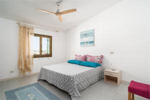 a bedroom with a bed and a ceiling fan at Azzurra in Orosei