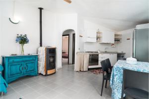 a kitchen with a blue cabinet and a table at Azzurra in Orosei