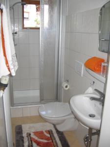 a bathroom with a toilet and a sink and a shower at Ferienwohnung Blattmann in Sankt Peter +5 photos