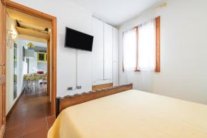 a bedroom with a bed and a flat screen tv at Casa Leo in Calasetta