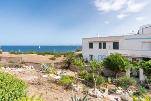 a house on the beach with the ocean in the background at Casa Leo in Calasetta