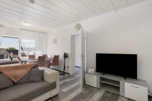 a living room with a couch and a flat screen tv at Ferienwohnung Cakir in Meinerzhagen