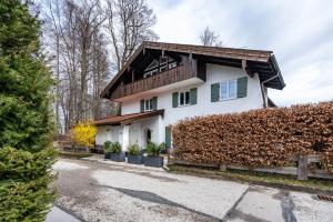 a white house with a wooden roof at Wohnung am See in Gmund am Tegernsee