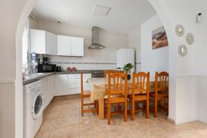 a kitchen with a table and chairs and a sink at Buganvilla in Pájara +17 photos