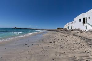 a beach with footprints in the sand and the ocean at Buganvilla in Pájara
