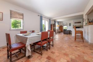 a dining room with a table and chairs at Madig Azul Maison Piscine Chauffée in La Trinité-sur-Mer