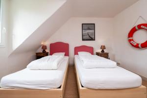 two twin beds in a attic room with a red circle on the wall at Madig Azul Maison Piscine Chauffée in La Trinité-sur-Mer +14 photos