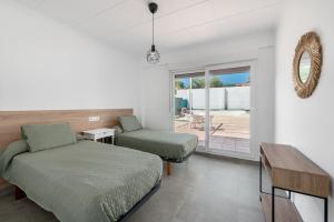 a bedroom with two beds and a desk and a window at La Bombonera 2 in Catadau +36 photos