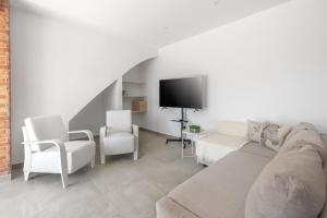 a living room with a couch and two chairs and a tv at La Bombonera 2 in Catadau