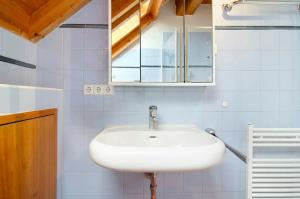 a bathroom with a white sink and a mirror at Ferienwohnung Saupp in Immenstaad am Bodensee