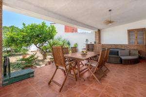 a dining room with a wooden table and chairs at La Bombonera 2 in Catadau