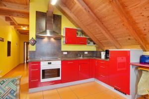 a kitchen with red cabinets and a stove at Ferienwohnung Saupp in Immenstaad am Bodensee