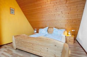 a bedroom with a large bed with a wooden ceiling at Ferienwohnung Saupp in Immenstaad am Bodensee +17 photos